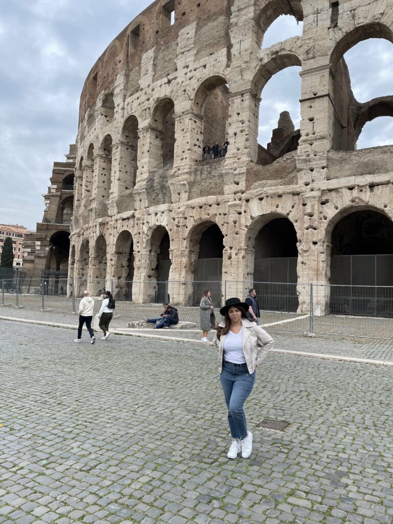 Photo of woman traveler outside Colosseum walls in 202.